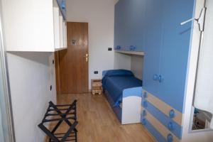 ein kleines Schlafzimmer mit einem blauen Bett und einem kleinen Stuhl in der Unterkunft Mirea's Rooms in Ascoli Piceno
