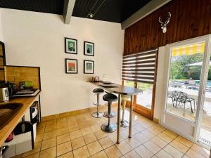 Suite Armagnac, relaxing gite near Nogaro في نوغارو: مطبخ مع طاولة وكراسي أمام نافذة