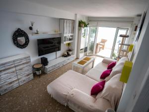 ein Wohnzimmer mit einem Sofa und lila Kissen in der Unterkunft Apartamento Beach View in Torremolinos