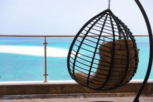 un'altalena su un balcone con vista sull'oceano di Triumph White Sands Hotel a Marsa Matruh