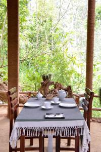 a table with a blue table cloth on it with chairs at Eco Village in Ella