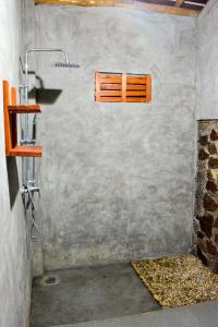 a bathroom with a shower with a window on the wall at Eco Village in Ella