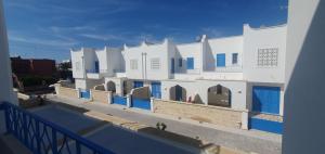a white building with blue doors and a swimming pool at La Dimora del Salento in Torre Lapillo