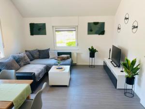 un soggiorno con un divano e una TV di Ferienwohnung Am Maarbach a Konz