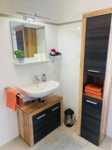a bathroom with a sink and a mirror at Ferienwohnung Am Maarbach in Konz