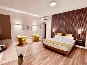 a hotel room with a bed and two chairs at Gelsi Luxury Suites in Sora