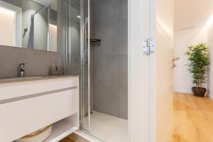 ein Bad mit einer Dusche und einem Waschbecken in der Unterkunft Precioso apartamento en la playa in Castelldefels