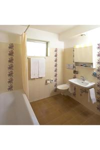 ein Badezimmer mit einer Badewanne und einem Waschbecken in der Unterkunft Al Pozz Boutique Resort in Locarno