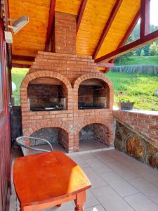 een bakstenen oven op een patio met een tafel bij Pensiunea Hășmaș in Lacu Rosu