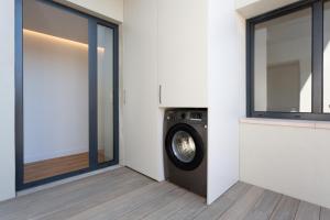 a washing machine in a room next to a window at Precioso apartamento en la playa in Castelldefels