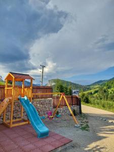 a playground with a slide at Pensiunea Hășmaș in Lacu Rosu