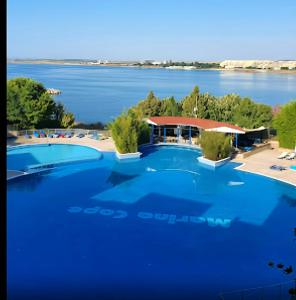 a large swimming pool with a view of the water at Marina Cape surprise studio in Aheloy