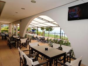 a restaurant with tables and chairs and a flat screen tv at Marina Cape surprise studio in Aheloy