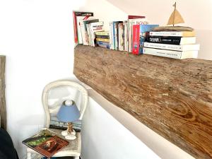 a shelf with books on a wall with a chair at Paris-Sète T2 au coeur de Sète in Sète