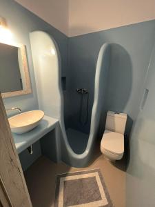 uma casa de banho com um lavatório, um WC e um chuveiro em Martin Rooms em Irakleia