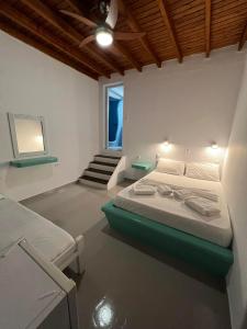1 dormitorio con 1 cama y escalera. en Martin Rooms, en Iraklia