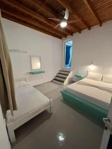 a bedroom with two beds and a staircase in it at Martin Rooms in Irakleia