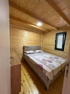 a bedroom with a bed in a wooden cabin at Sojenica Tamara in Ulcinj