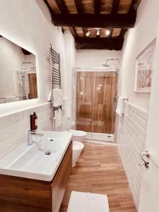 a white bathroom with a sink and a shower at Gelsi Luxury Suites in Sora