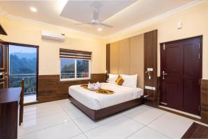 a bedroom with a bed and a large window at Star Emirates Luxury Resort and Spa, Munnar in Anachal