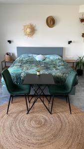 a bedroom with a bed and a table with a green tufted mattress at Bed no breakfast de Kapitein in 't Horntje
