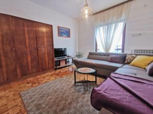 ein Wohnzimmer mit einem Sofa und einem TV in der Unterkunft Apartments Marijana in Vodice