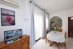 een woonkamer met een tafel en een televisie bij Apartments Tonja in Primošten