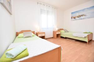 een kleine slaapkamer met 2 bedden en een raam bij Apartments Tonja in Primošten
