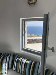 una finestra in una camera con divano e oceano di Anemos Windmill a Vourvoúlos
