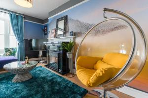 a living room with a yellow couch and a fire place at Starling View BOUTIQUE Stunning Seafront view Apartment in Aberystwyth