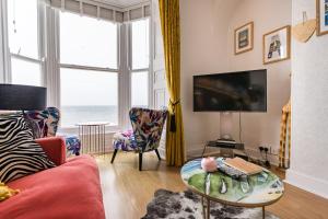 a living room with a couch and a table at Sea view Ar Lan y Mor LUXURY APARTMENT in Aberystwyth