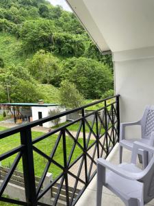 a balcony with two chairs and a view of a mountain at Villa Mountview in Gonio