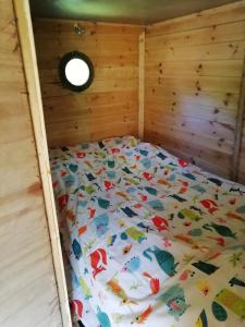 uma cama num caixilho de madeira num quarto em Truck & Pod creative nature retreat. em Bantry