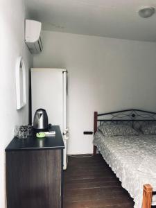 a small room with a bed and a refrigerator at apartamienty "Pozitiv" in Karolino-Buhaz