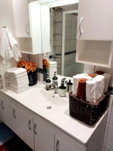 a bathroom with a sink with towels and a mirror at Høy standard. Mye for pengene. Gratis velkomstgave in Narvik