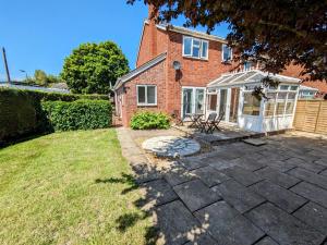 a brick house with a patio and a white gazebo at Leominster 3 Bedroom House, Private Parking and Garden in Leominster