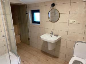bagno con lavandino, servizi igienici e specchio di Villa Mountview a Gonio