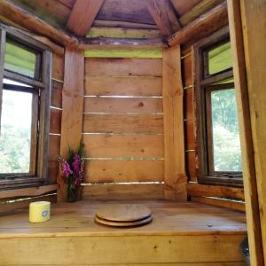 a room in a log cabin with two windows at Truck & Pod creative nature retreat. in Bantry