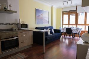 sala de estar con sofá azul y mesa en Precioso piso en San Ciprián, en San Ciprián
