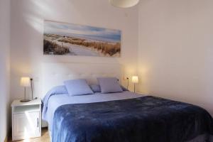1 dormitorio con 1 cama y una pintura en la pared en Precioso piso en San Ciprián, en San Ciprián