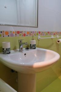 lavabo blanco en el baño con espejo en Precioso piso en San Ciprián, en San Ciprián