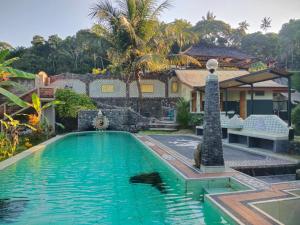 a swimming pool in front of a house at Dau Homestay in Tirtagangga