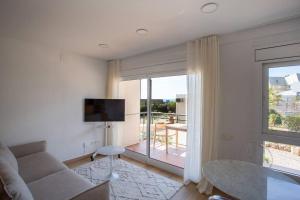 sala de estar con sofá, mesa y ventana en A pie de playa en Gavá mar!, en Gavà