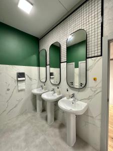 a bathroom with two sinks and two mirrors at izzzi hostel in Bishkek