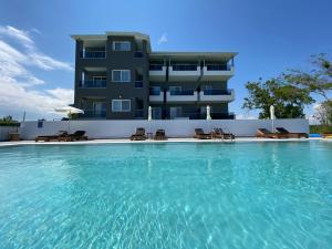 奥林匹亚基·阿克蒂Olympus Diamond studios的一座大楼前带椅子的游泳池