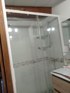 La salle de bains est pourvue d'une douche avec une porte en verre. dans l'établissement Le Nid de Laly, à Ustou
