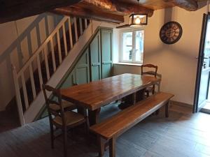 a wooden table and bench in a room with stairs at Le Nid de Laly in Ustou