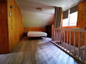 a bedroom with a bed in a room with wooden walls at Le Nid de Laly in Ustou