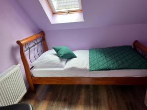 - un lit avec des draps verts et blancs et une fenêtre dans l'établissement Zatoczka Turawa, à Turawa