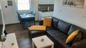 sala de estar con sofá de cuero negro y mesa en Apartma Lima en Ankaran